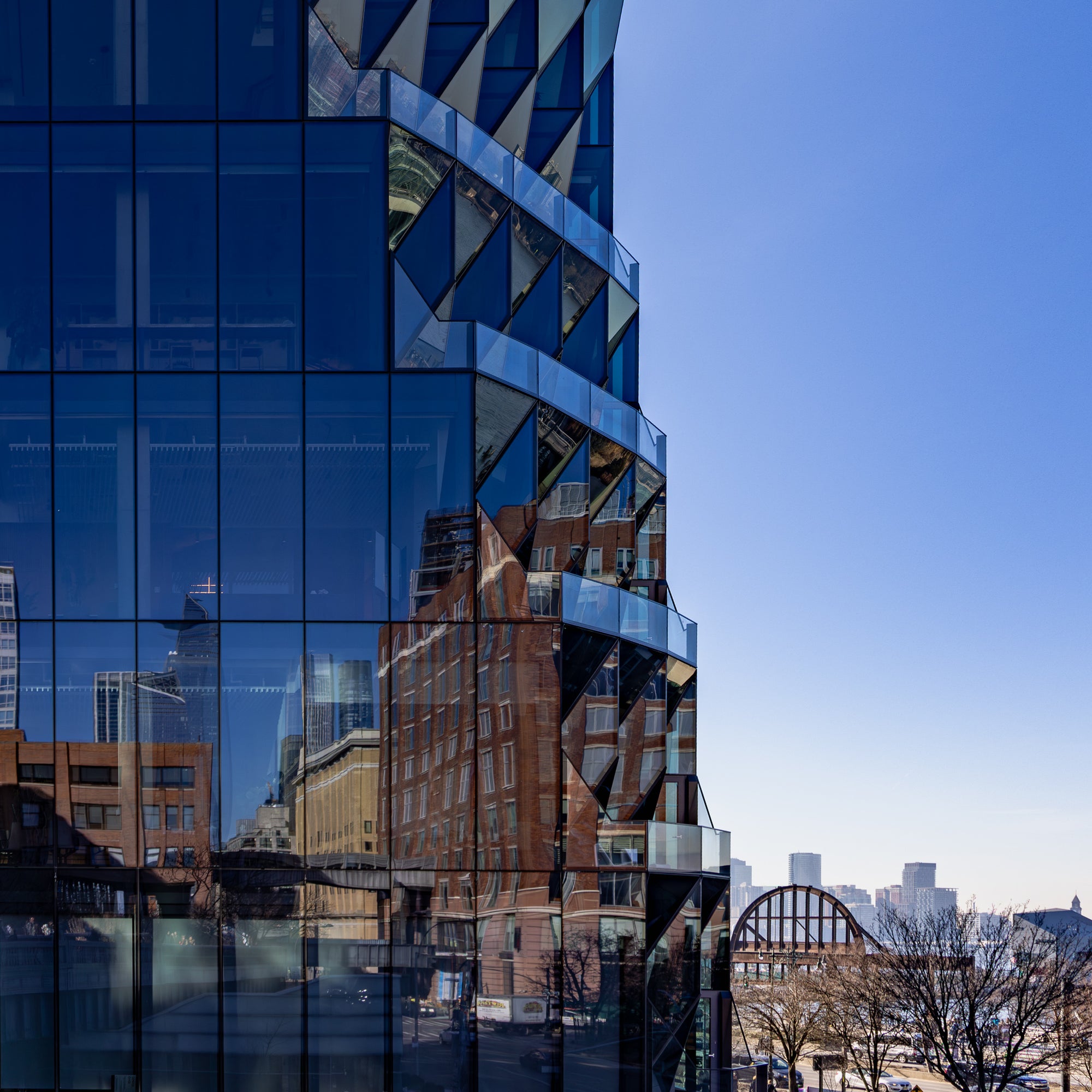 Modern glass building with cityscape reflection on a clear day