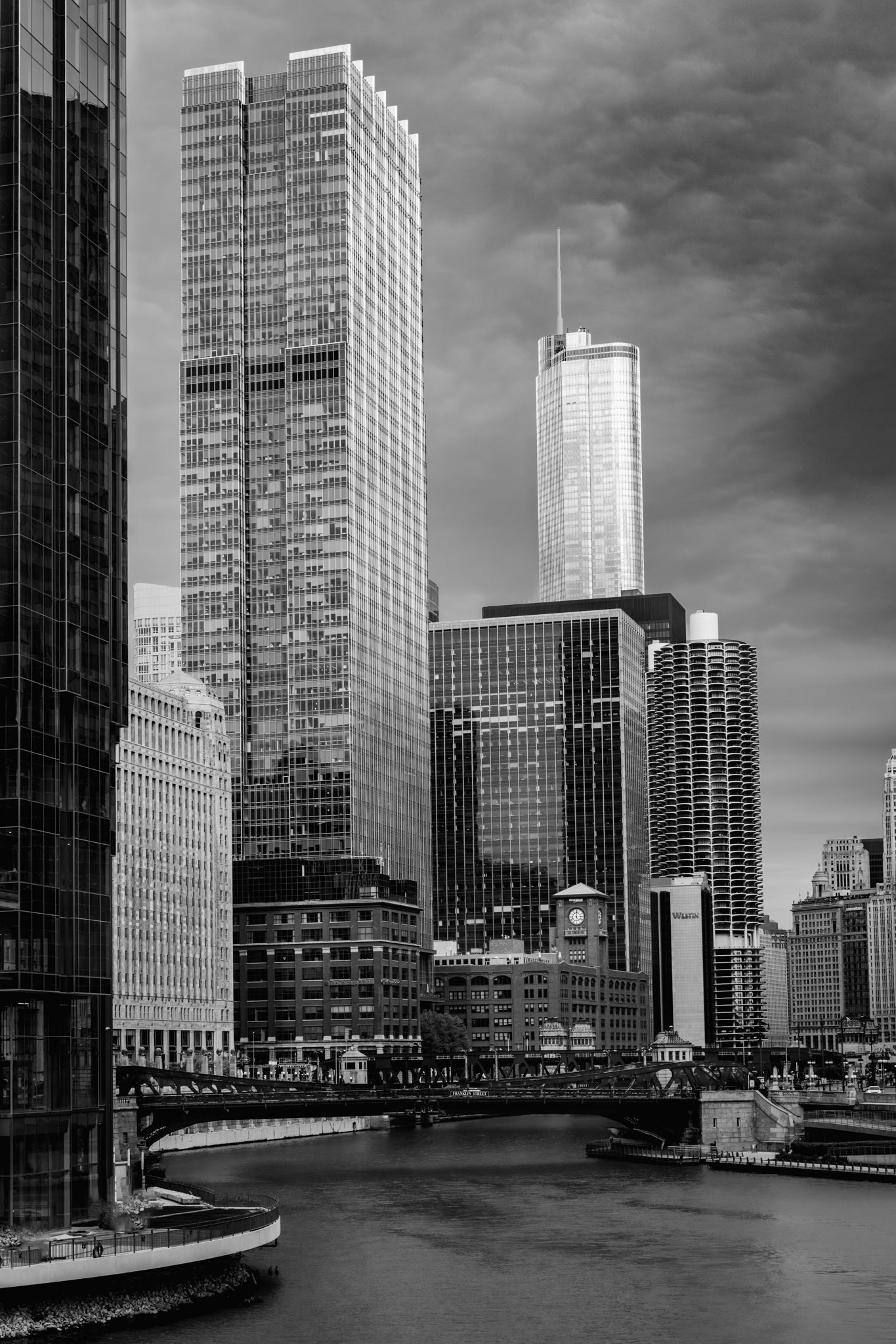 Black and white cityscape with tall buildings and a river