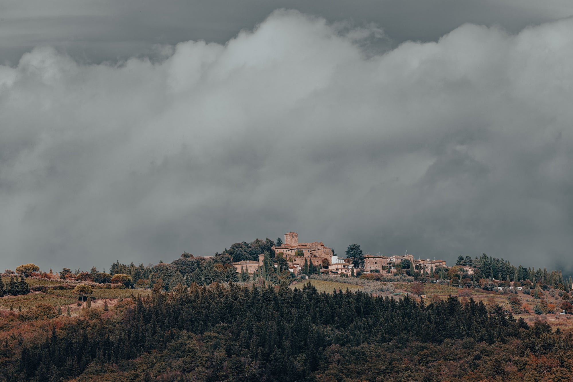Village on a hill with large clouds in the sky