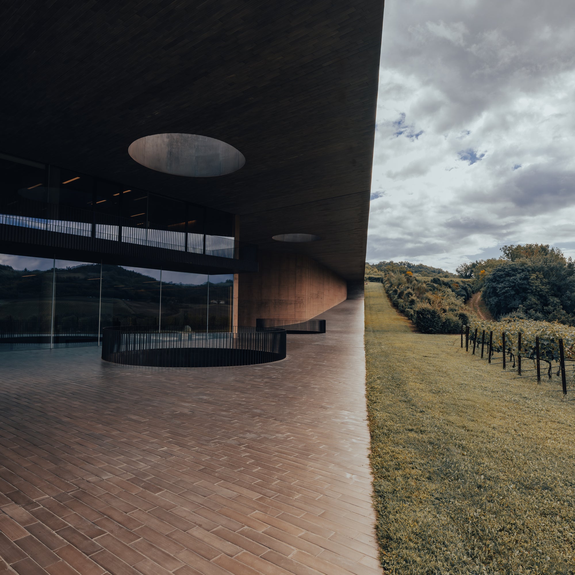 Modern architectural structure with a pathway leading to it, under a cloudy sky.