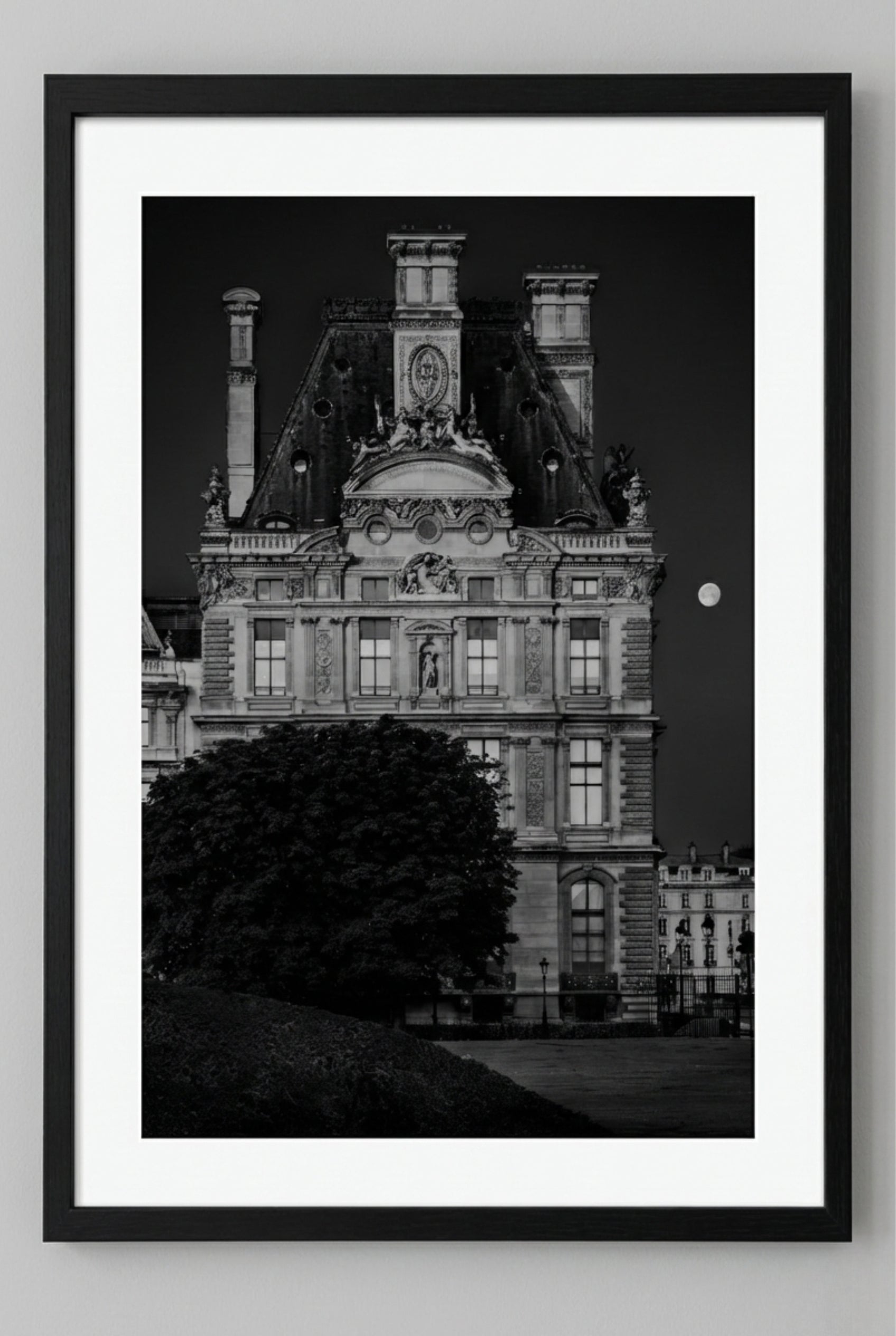 Black and white framed photograph of a historic building with a moonlit sky.