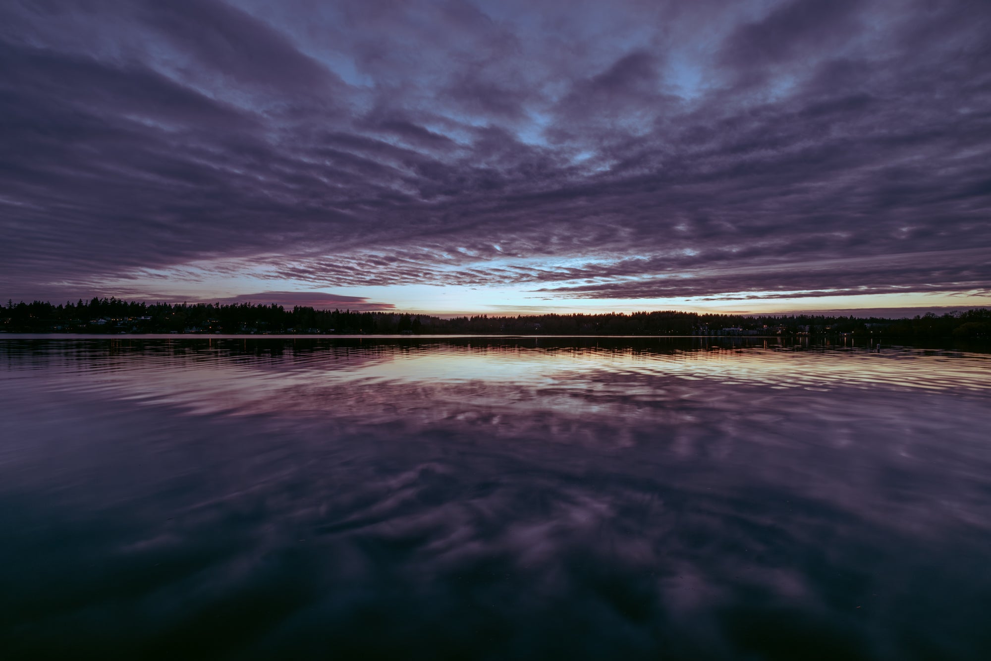 Evening sky with purple and blue hues over a calm lake