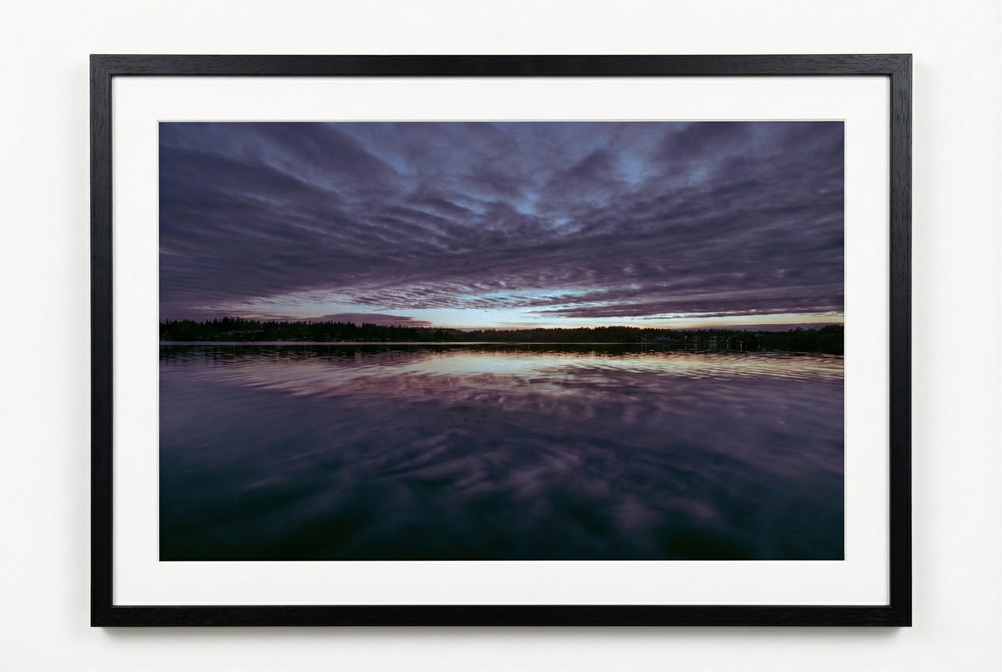 Framed photograph of a sunrise over water with purple and blue hues.