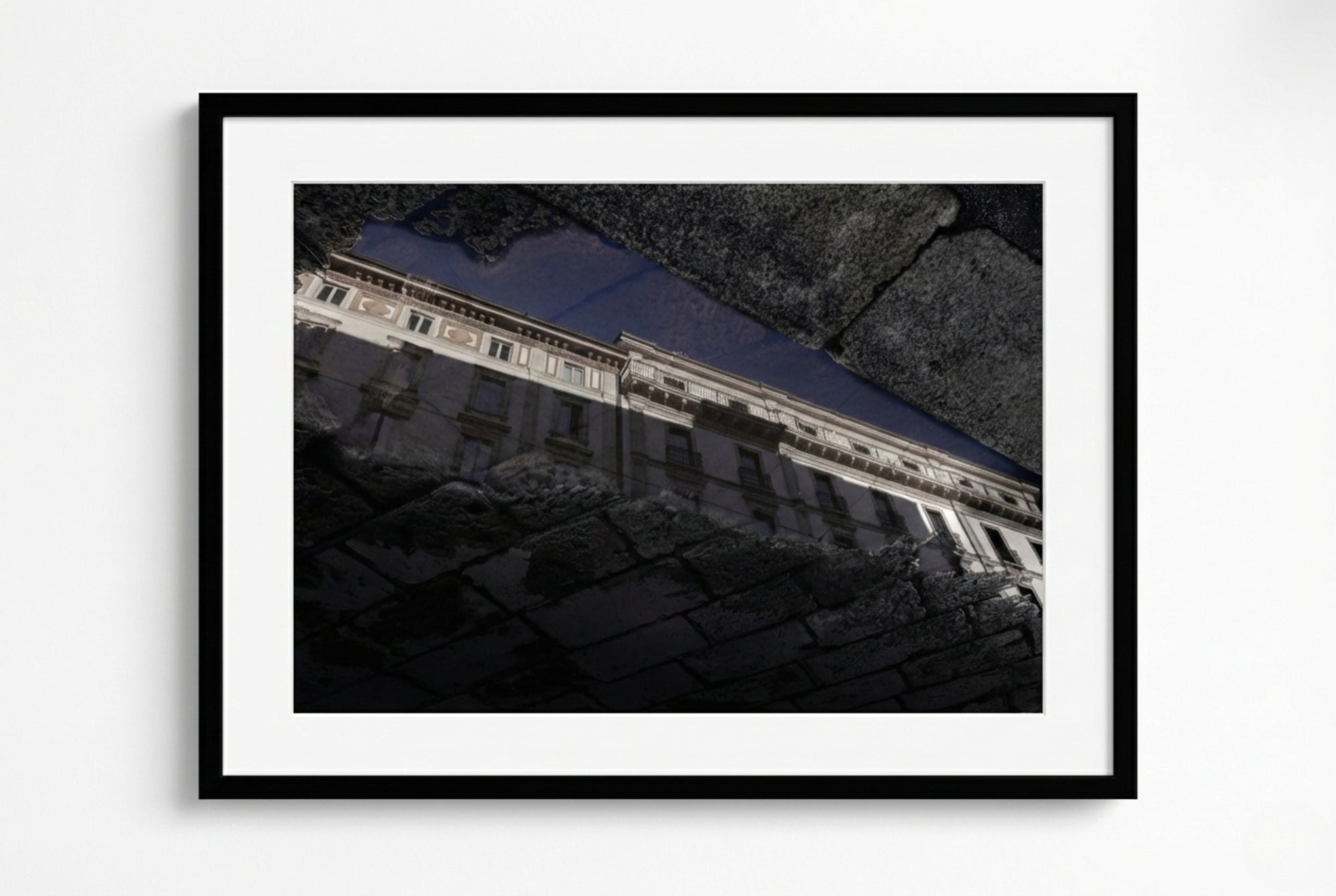 Framed photograph of a building with a dark roof against a light background