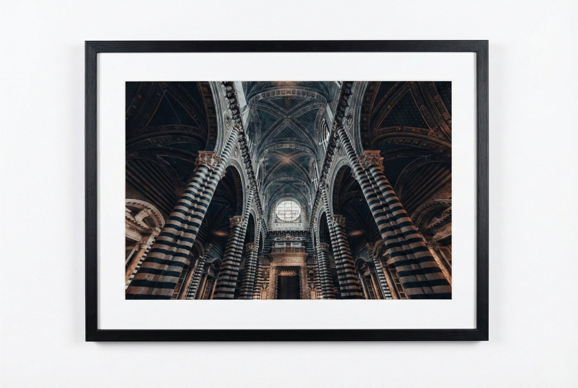 Framed photograph of a cathedral interior with high arches and a central light source.