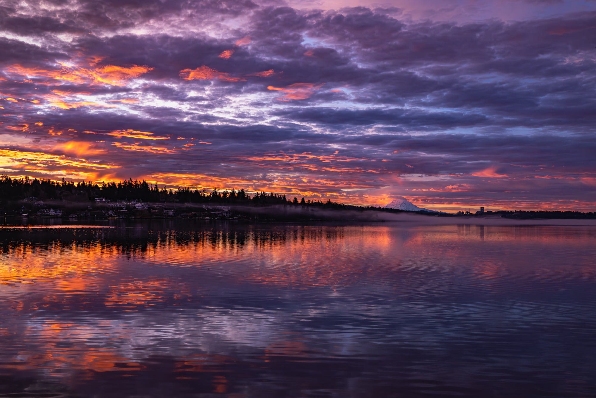 Sunrise over a lake with colorful clouds reflecting on the water