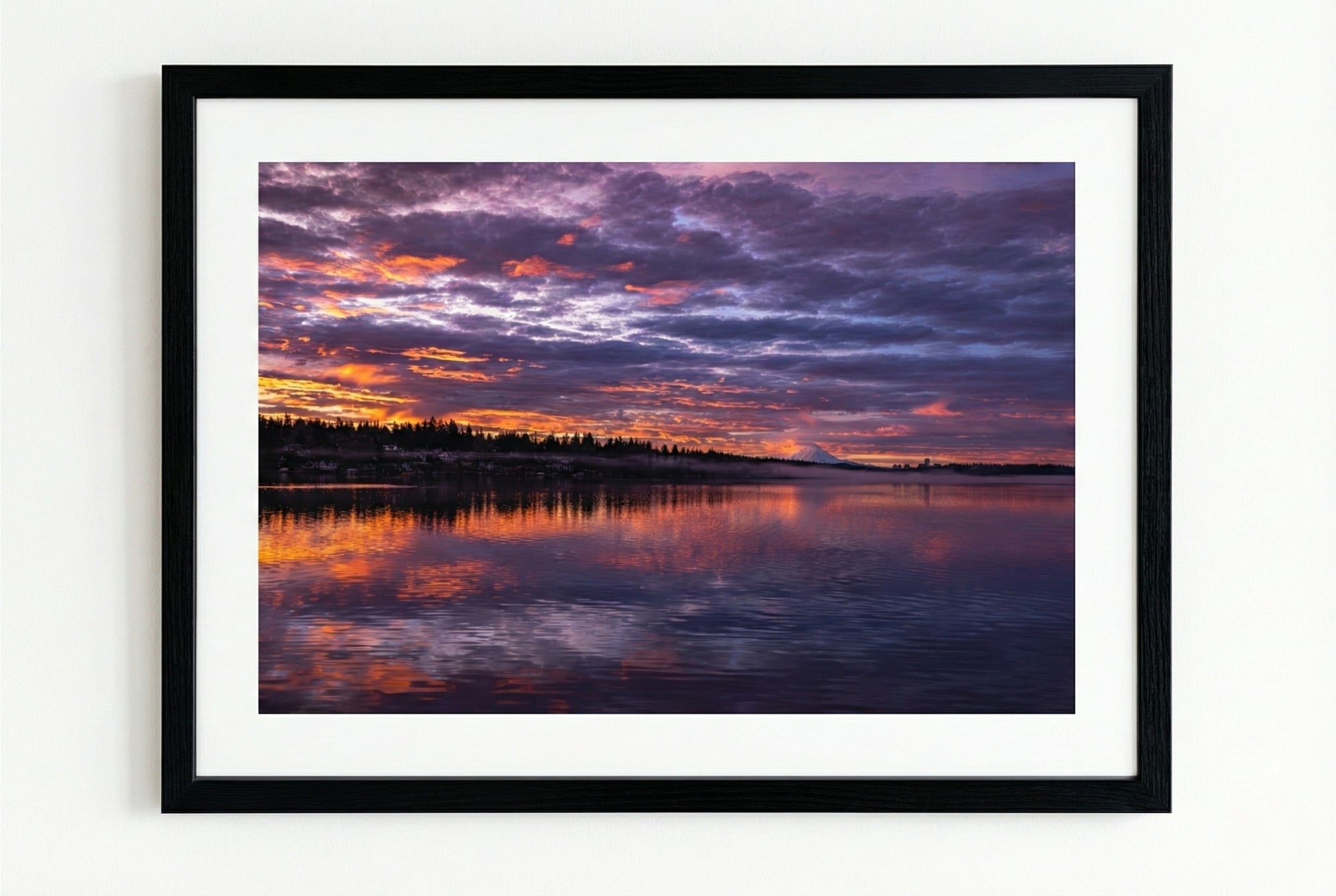 Framed artwork of a sunrise over water with purple and orange hues.