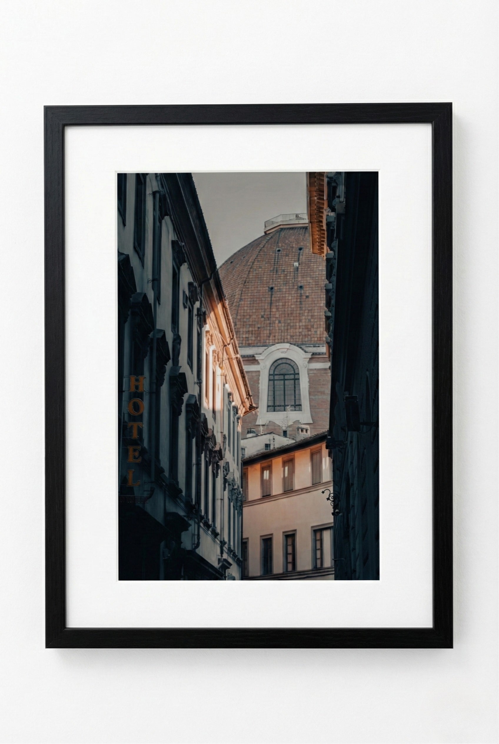 Framed photograph of a city street with buildings and lights.