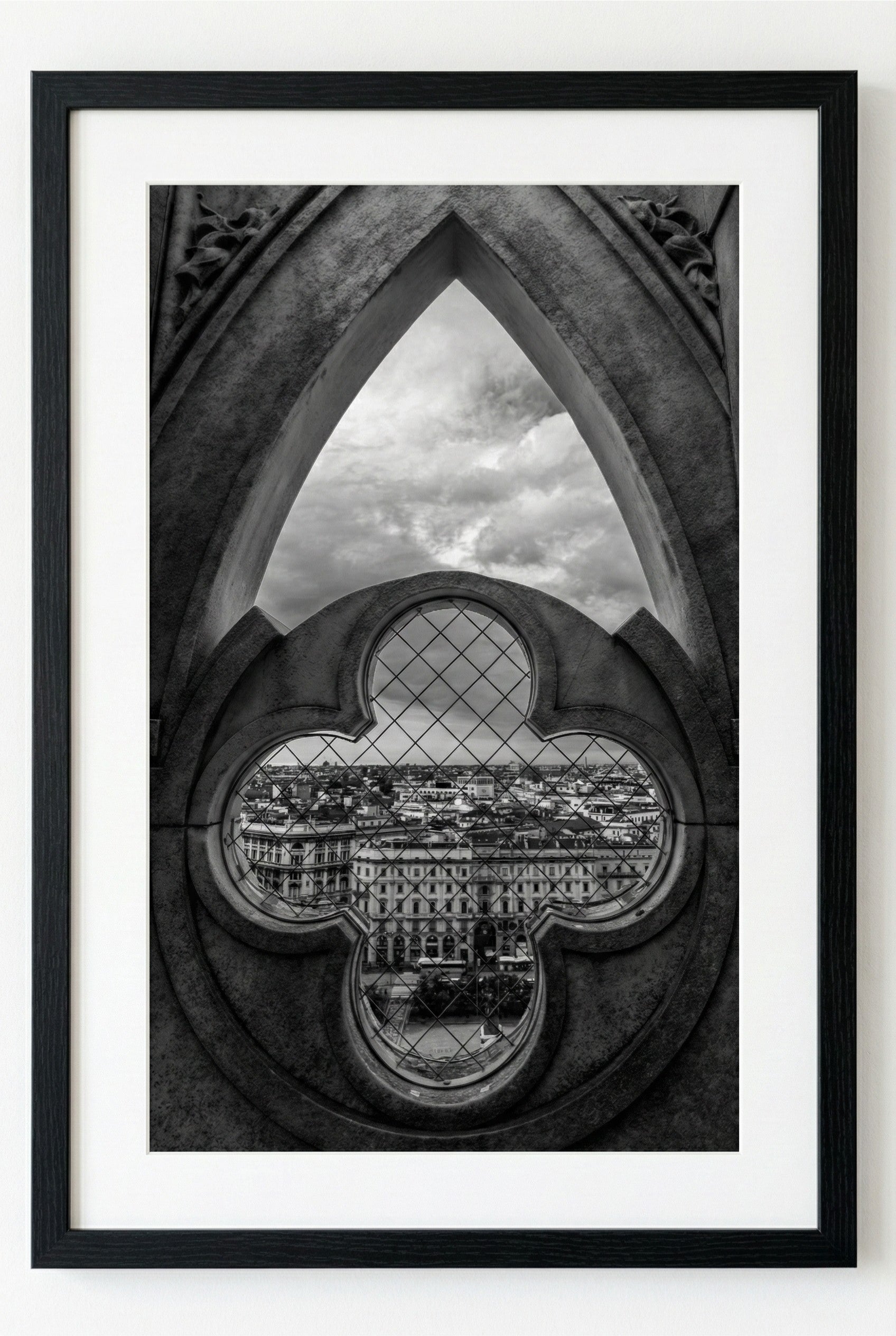 Framed black and white photograph of a cityscape through a decorative window