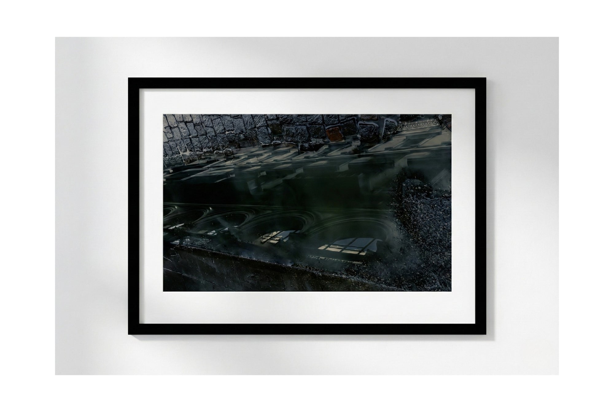 Framed photograph of a dark, possibly underwater scene with a black frame on a white background