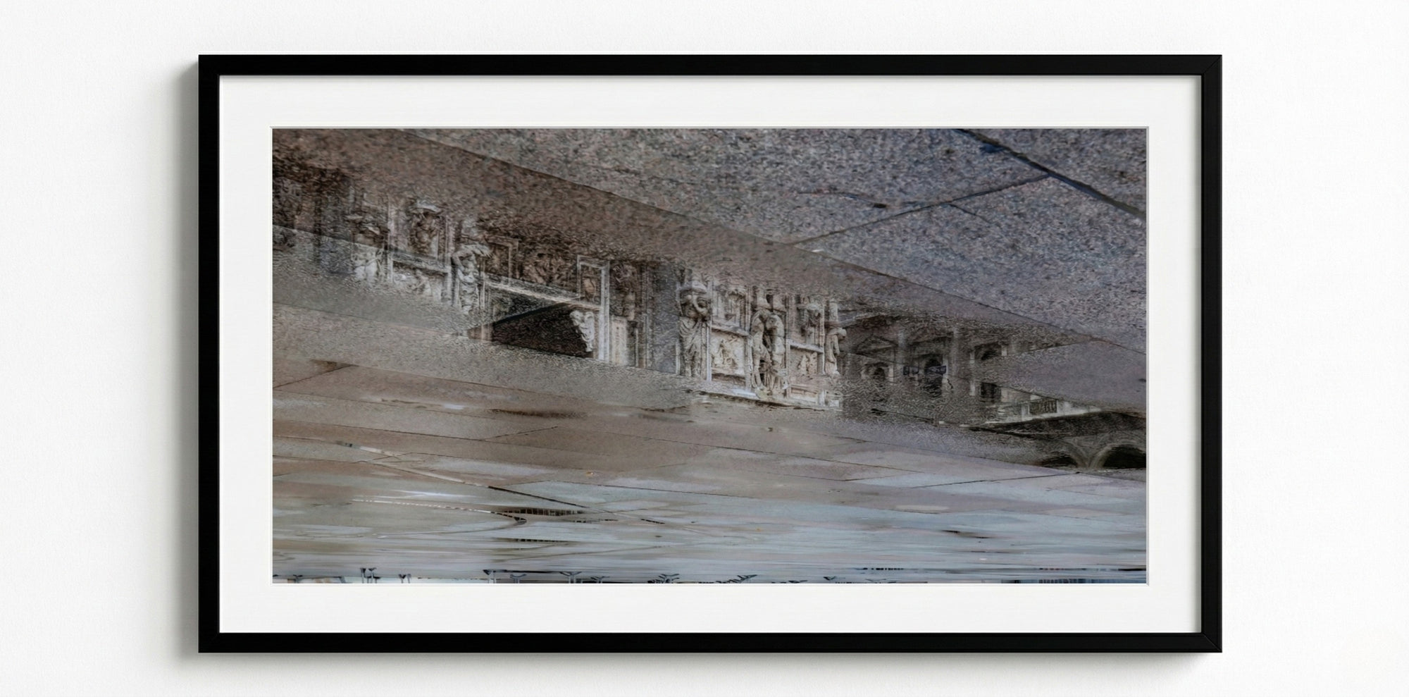 Framed artwork of a reflection on cobblestone of a building