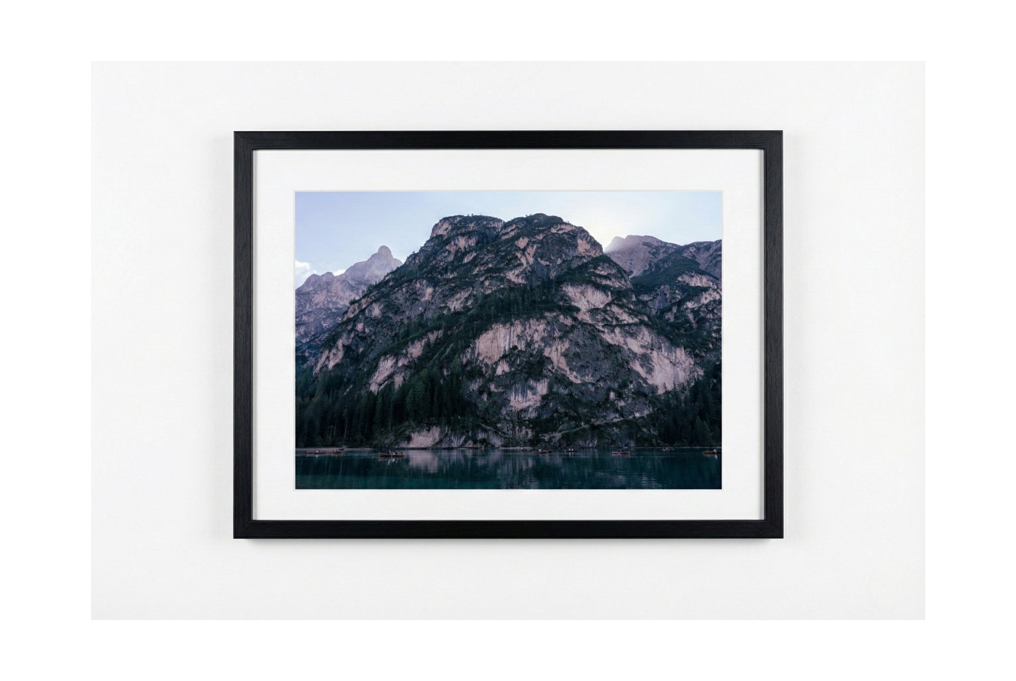 Framed photograph of mountains on a white wall
