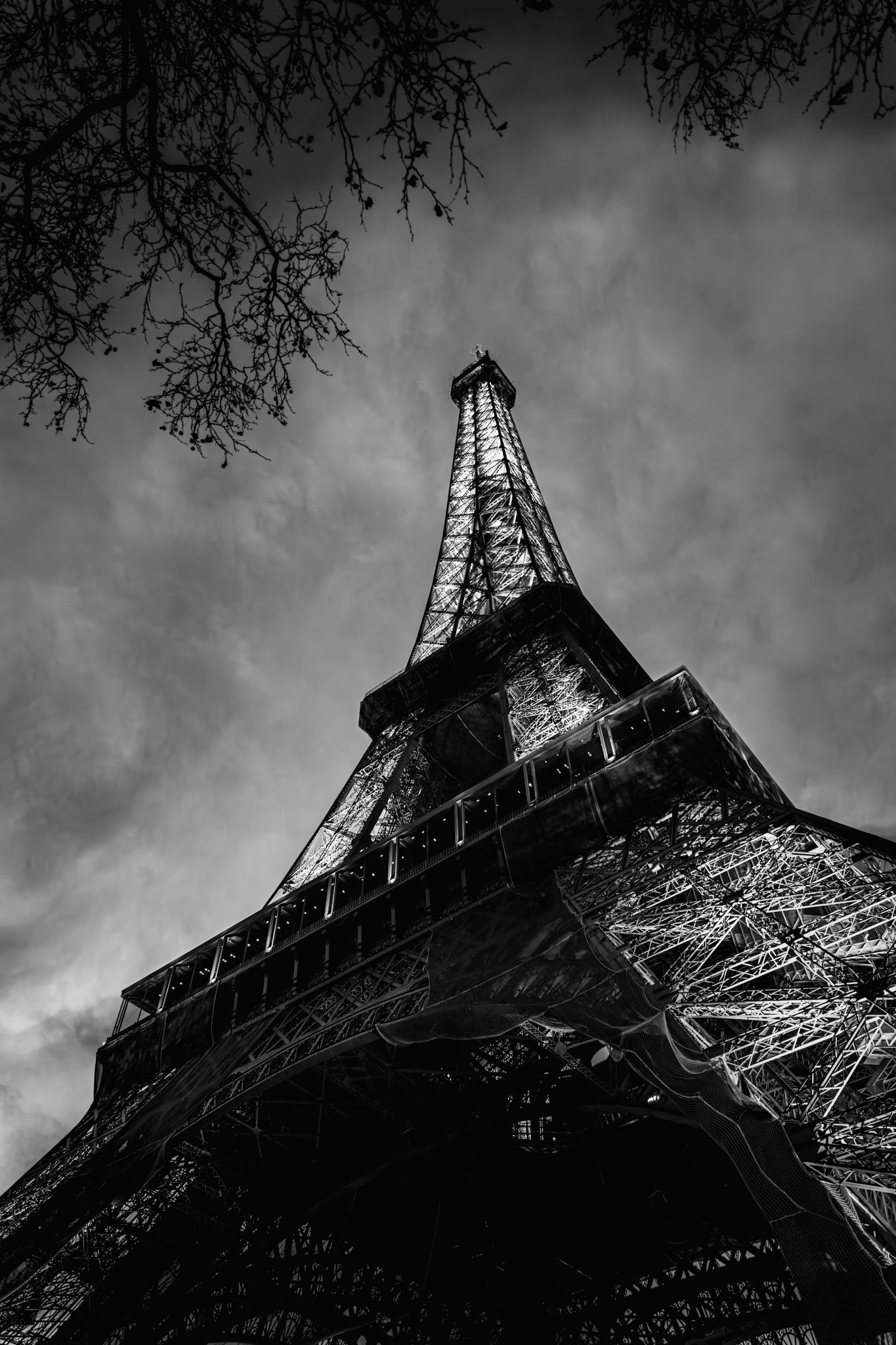Black and white image of the Eiffel Tower against a cloudy sky