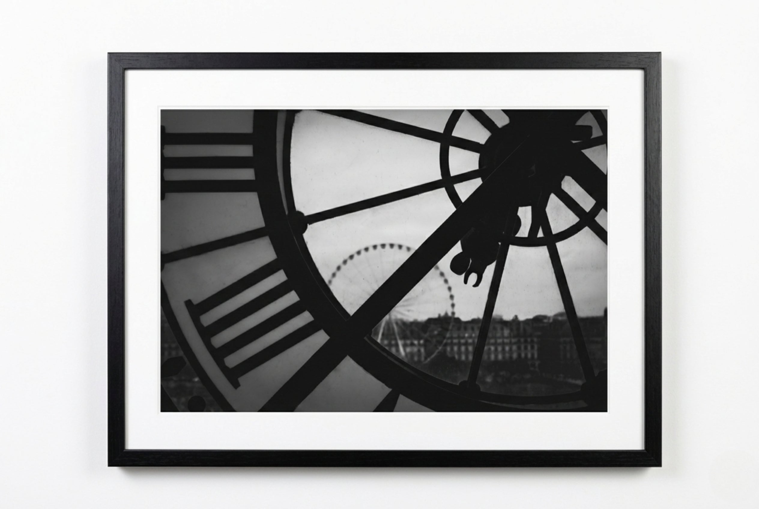 Framed black and white photograph of a clock with a cityscape in the background